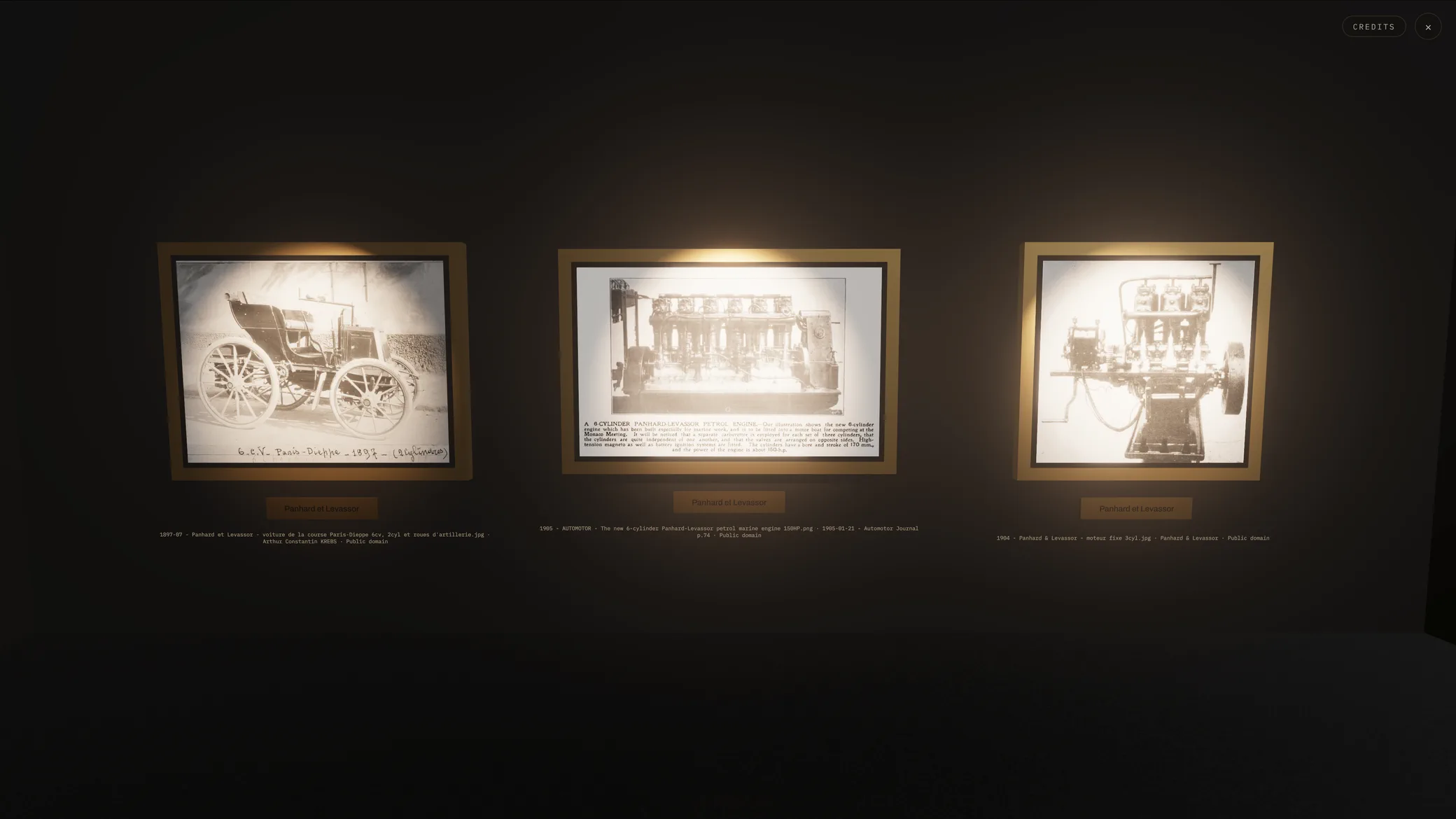 Three gold-framed sepia photographs lit on a dark wall of the real-time 3D museum, each with a Panhard et Levassor plaque and a Public domain attribution line.